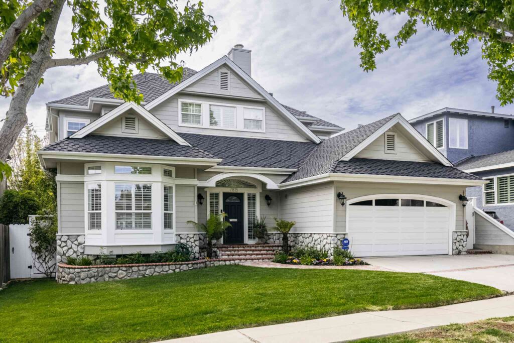 A stylish home exterior with an upgraded driveway, new front door, and outdoor kitchen, showcasing high-ROI remodeling projects.
