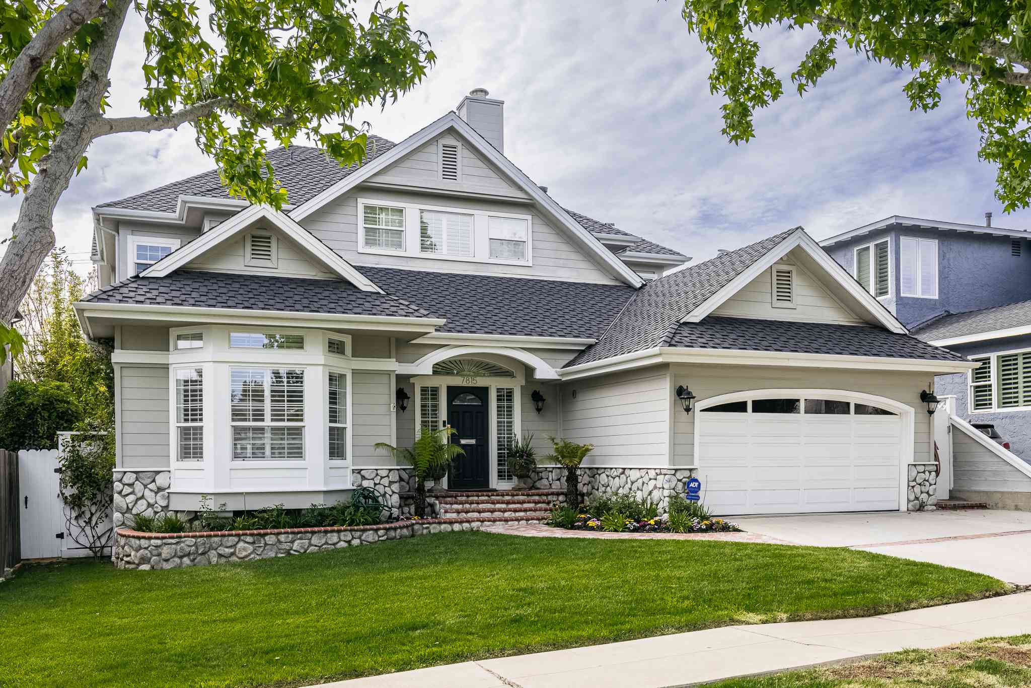 A stylish home exterior with an upgraded driveway, new front door, and outdoor kitchen, showcasing high-ROI remodeling projects.