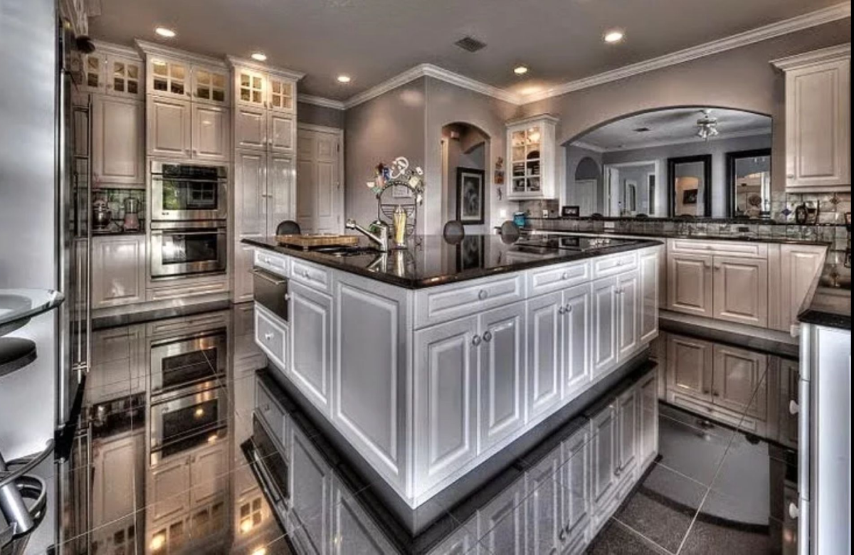 Luxury kitchen remodel in Austin with marble waterfall island and hidden appliances by Together Design Build
